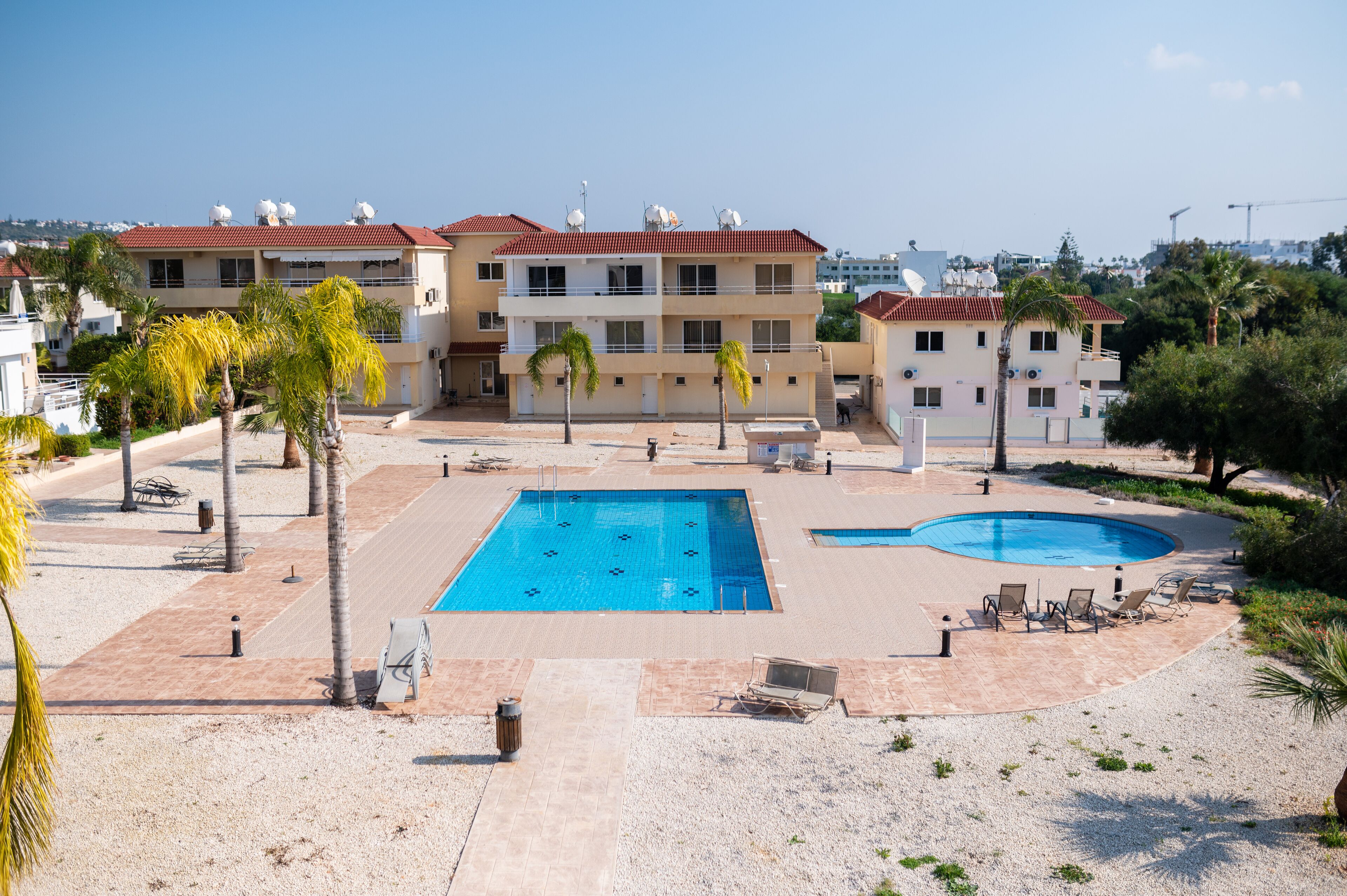 Ein Hotel mit Schwimmbad, Palmen und Meerblick.