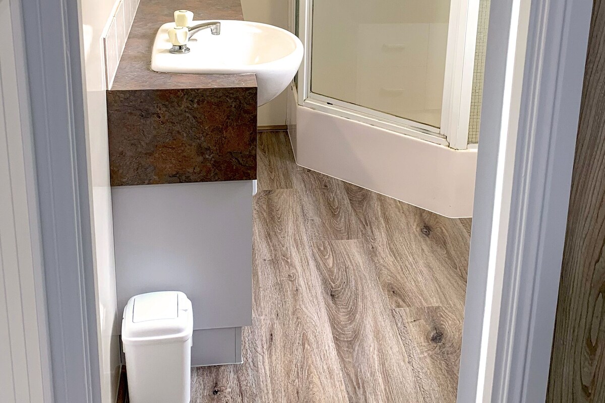 A bathroom with a shower, a sink, and a toilet.