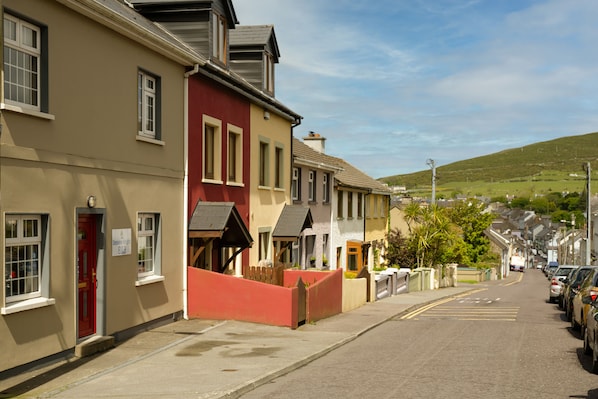 Række af byhuse med rødt dør, skilt der angiver et gebyr, og frit udsyn til gaden.