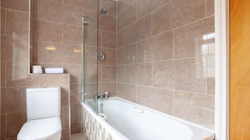 A modern bathroom with a glass-enclosed shower, a white toilet, and a freestanding bathtub.