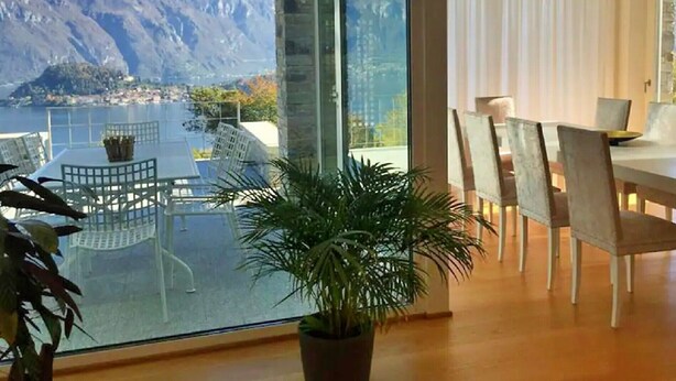 Un espace de restauration moderne offrant une vue sur les montagnes et un lac.