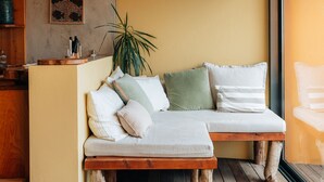 Ein gemütliches Zimmer mit einer Holzbanksofa, Holzboden und einem großen Fenster.