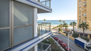 Un edificio moderno con un balcone che si affaccia su una spiaggia e l'oceano.