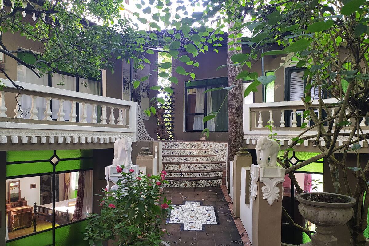 Un patio con piso de baldosas, una estatua blanca y una planta en maceta.