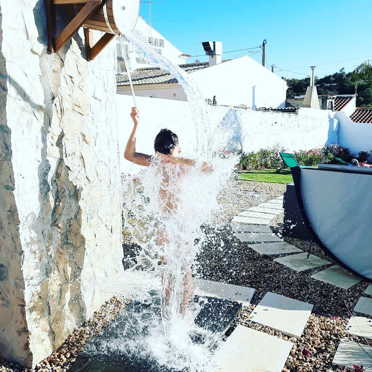 A person playing with water from a wall-mounted faucet.