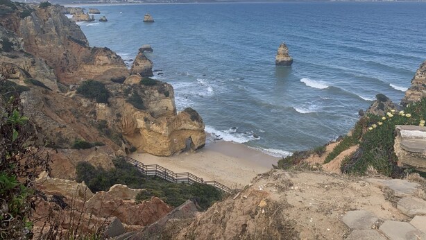 A coastal landscape with rocky cliffs, a sandy beach, and a clear blue sea. - Carvoeiro B&B and SPA (Lagoa)