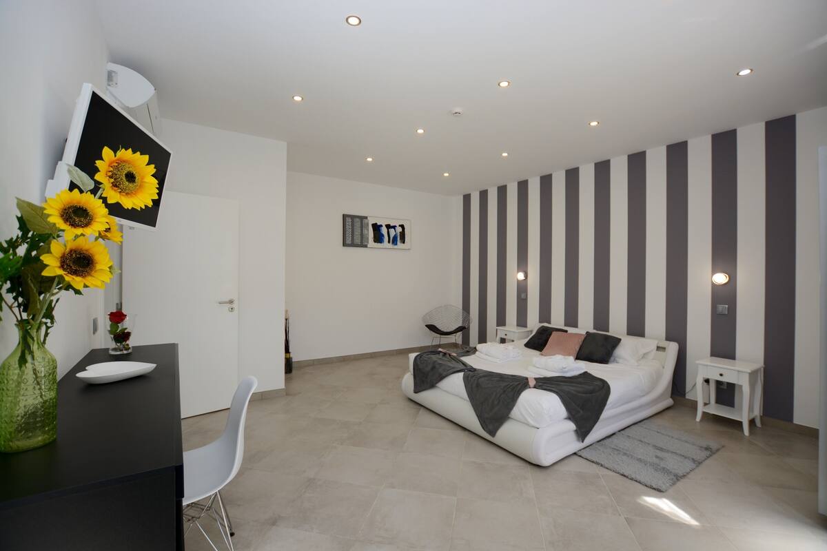 A modern bedroom with a bed, a desk, and a chair.