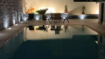 Una piscina al aire libre de temporada, sombrillas