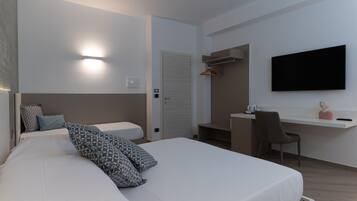 Una camera d'albergo moderna con un letto grande, una scrivania e una TV a schermo piatto.