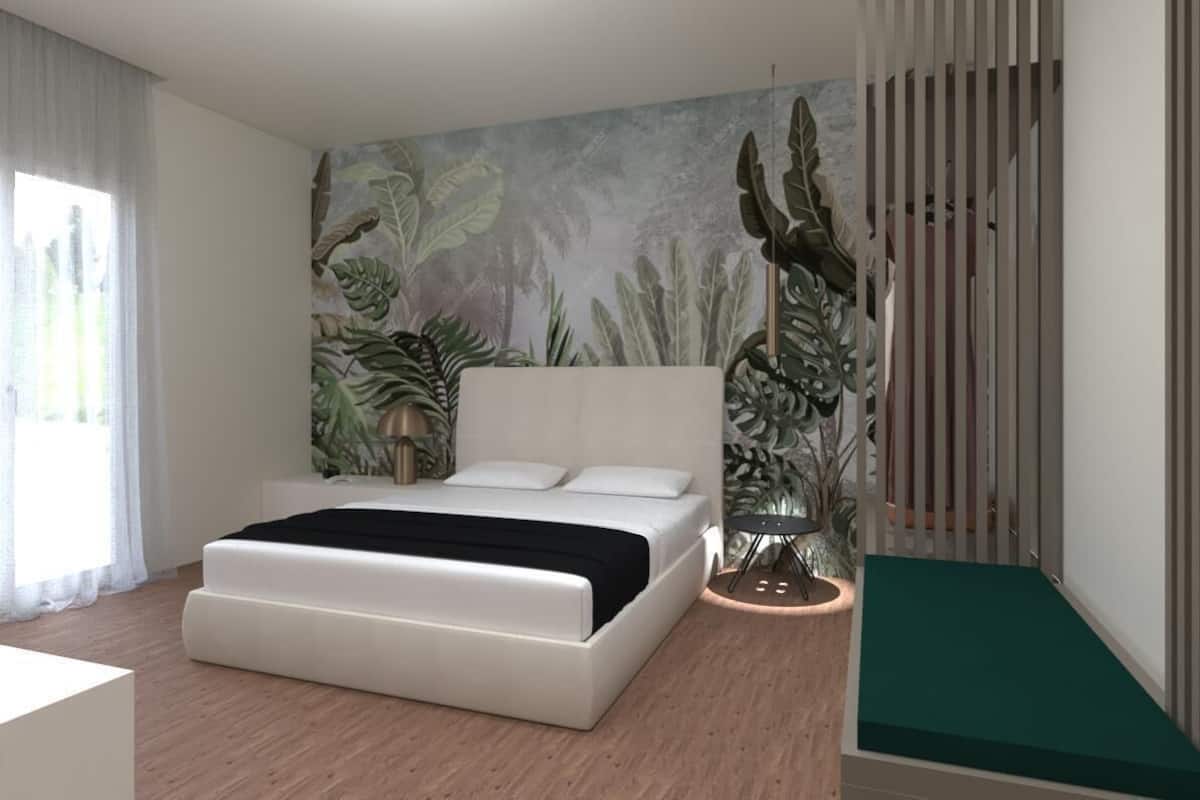 A modern bedroom with a large bed, a mural of tropical plants on the wall, and a small round table with a lamp.