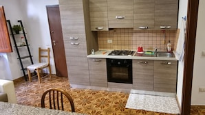 Una cucina compatta con mobili in legno, un fornello a gas e un lavello.