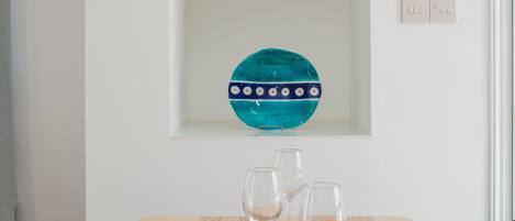 A dining table set with plates, glasses, and placemats.