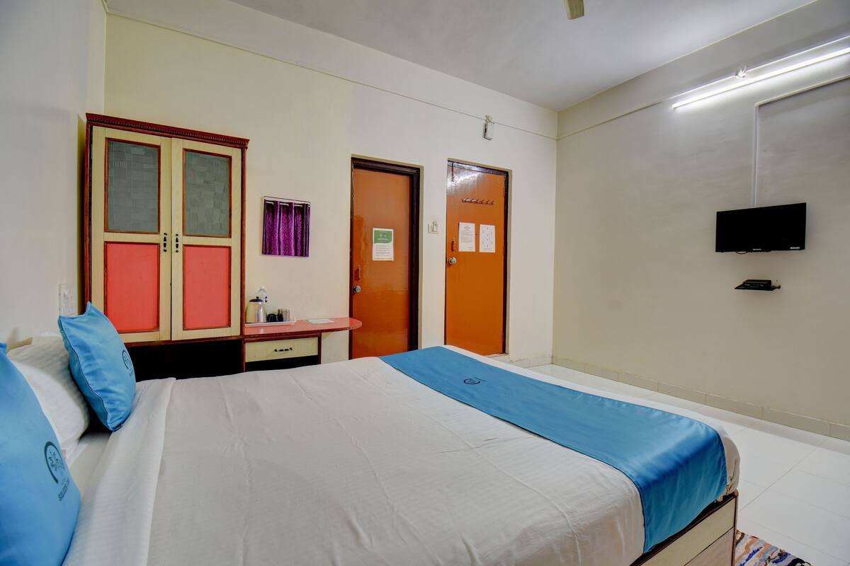 Une chambre d’hôtel équipée d’un lit, d’un bureau, d’une armoire et d’un téléviseur.