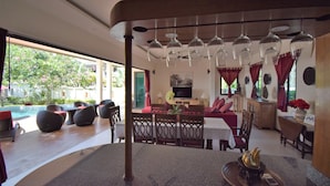 A dining area with a pool view, a TV, and a wooden ceiling. - 4 Bedroom Villa with Private Pool in Walled Garden (Mae Nam)