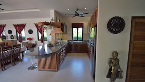 A spacious kitchen with a central island, wooden cabinets, and a ceiling fan. - 4 Bedroom Villa with Private Pool in Walled Garden (Mae Nam)