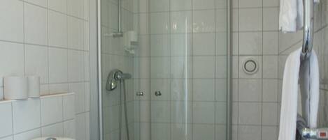 A modern bathroom with a glass-enclosed shower, a white toilet, and a towel rack.