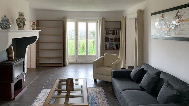 Ein Wohnzimmer mit Kamin, einer Couch, einem Couchtisch und einem Bücherregal.
