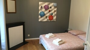 Ein Schlafzimmer mit einem Bett, einem Spiegel und einem Wandbild.