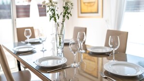 A dining table set with plates, glasses, and cutlery, with chairs around it. - Narcissos Villa 2 (Paralimni)