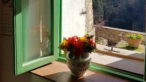 A window with a green frame and a view of a mountainous landscape. - The Photographer's House (Colle di Val d'Elsa)