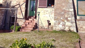 A rustic stone building with multiple windows, a satellite dish, and a small staircase leading to a door. - The Photographer's House (Colle di Val d'Elsa)