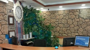 A reception desk with a clock, framed certificates, and a welcome sign for Carsi Hotel & Cafe. - Carsi Otel (Trabzon)