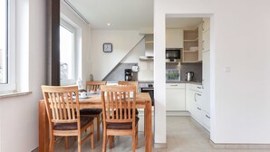 A modern kitchen with white cabinets, a microwave, and a coffee maker. - Apartment top right - House Albatros (Neuharlingersiel)