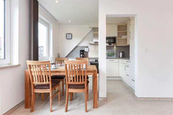 A modern kitchen with white cabinets, a microwave, and a coffee maker.