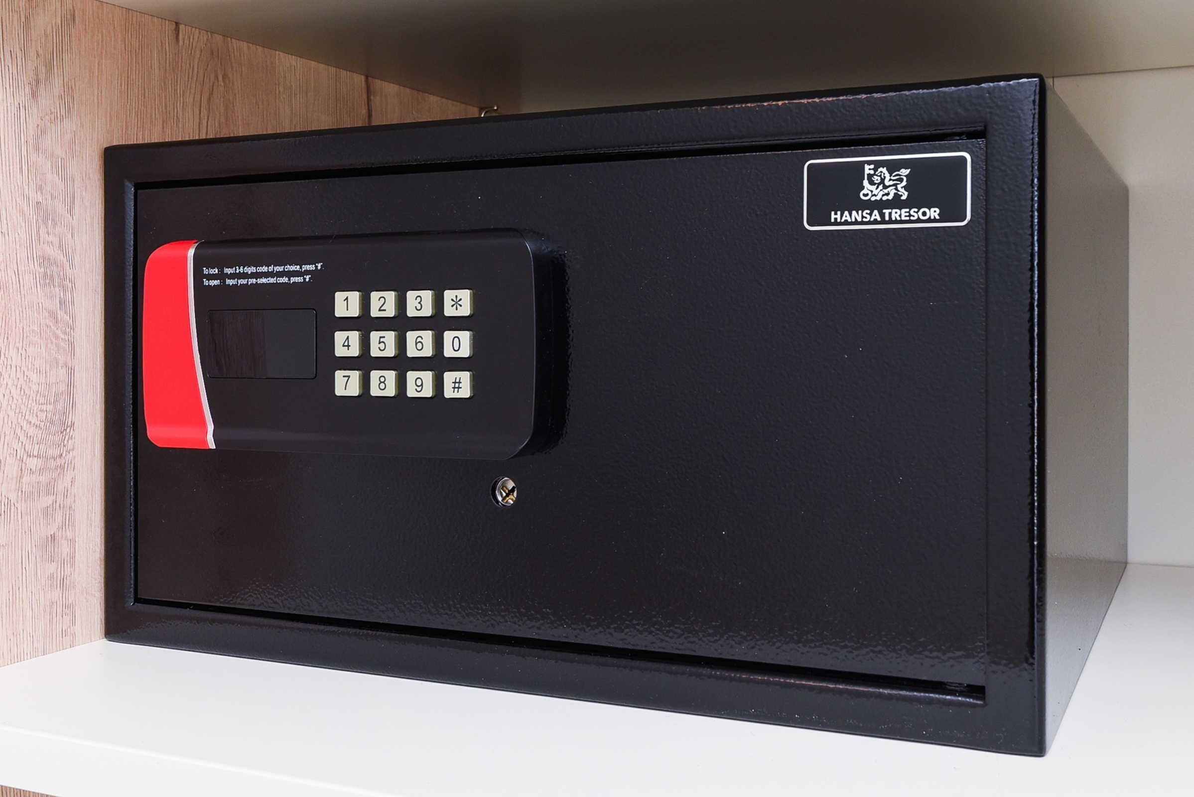 A black safe with a red keypad and a Hansa Tresor logo.