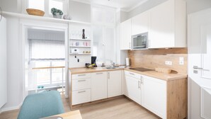 Eine moderne Küche mit weißen Schränken, einer Holzausziehtheke und einem eingebauten Ofen.