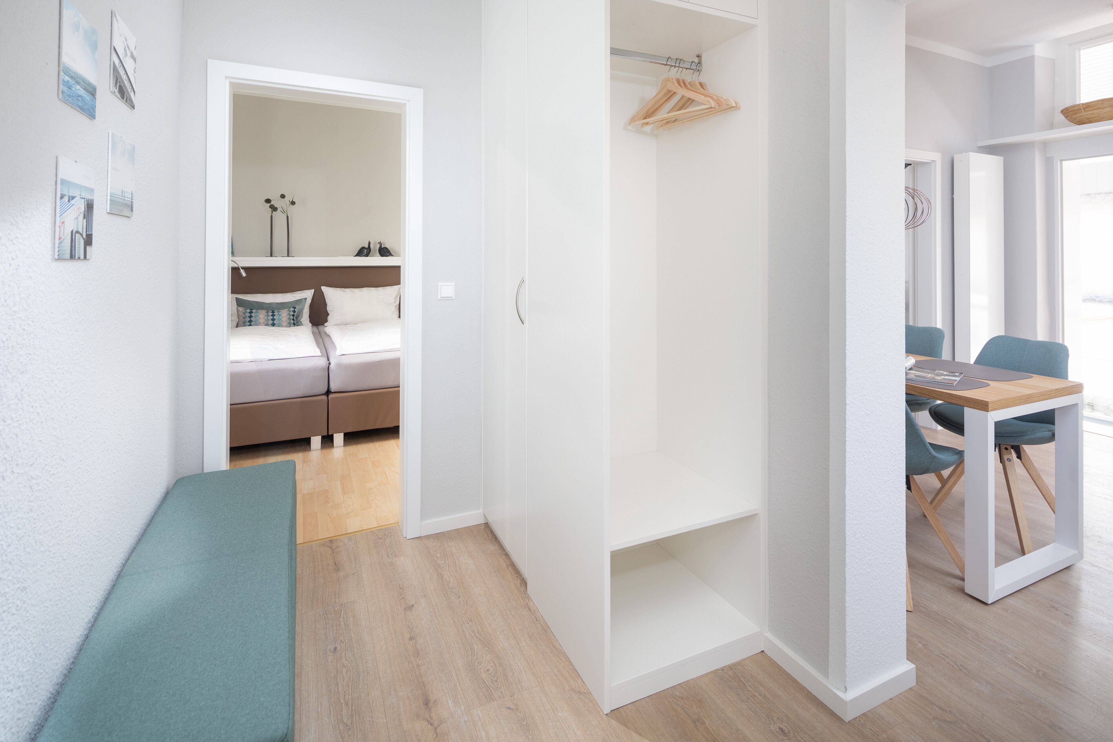 A modern, well-lit room with a bed, a desk, and a bench.