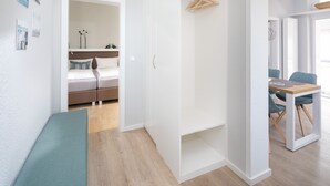 Ein modernes, helles Zimmer mit einem Bett, einem Schreibtisch und einer Bank.