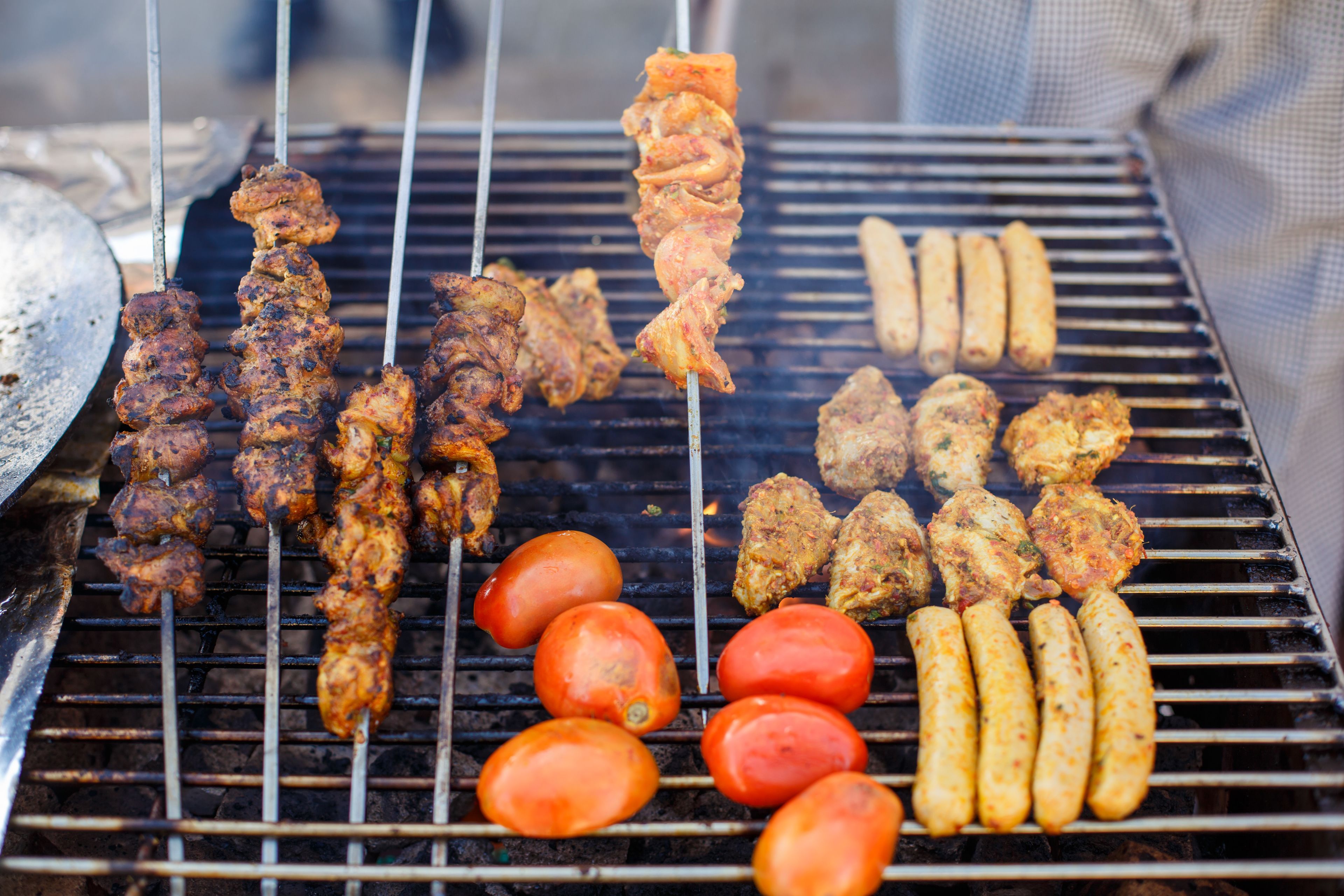 A grill with various meats and vegetables.