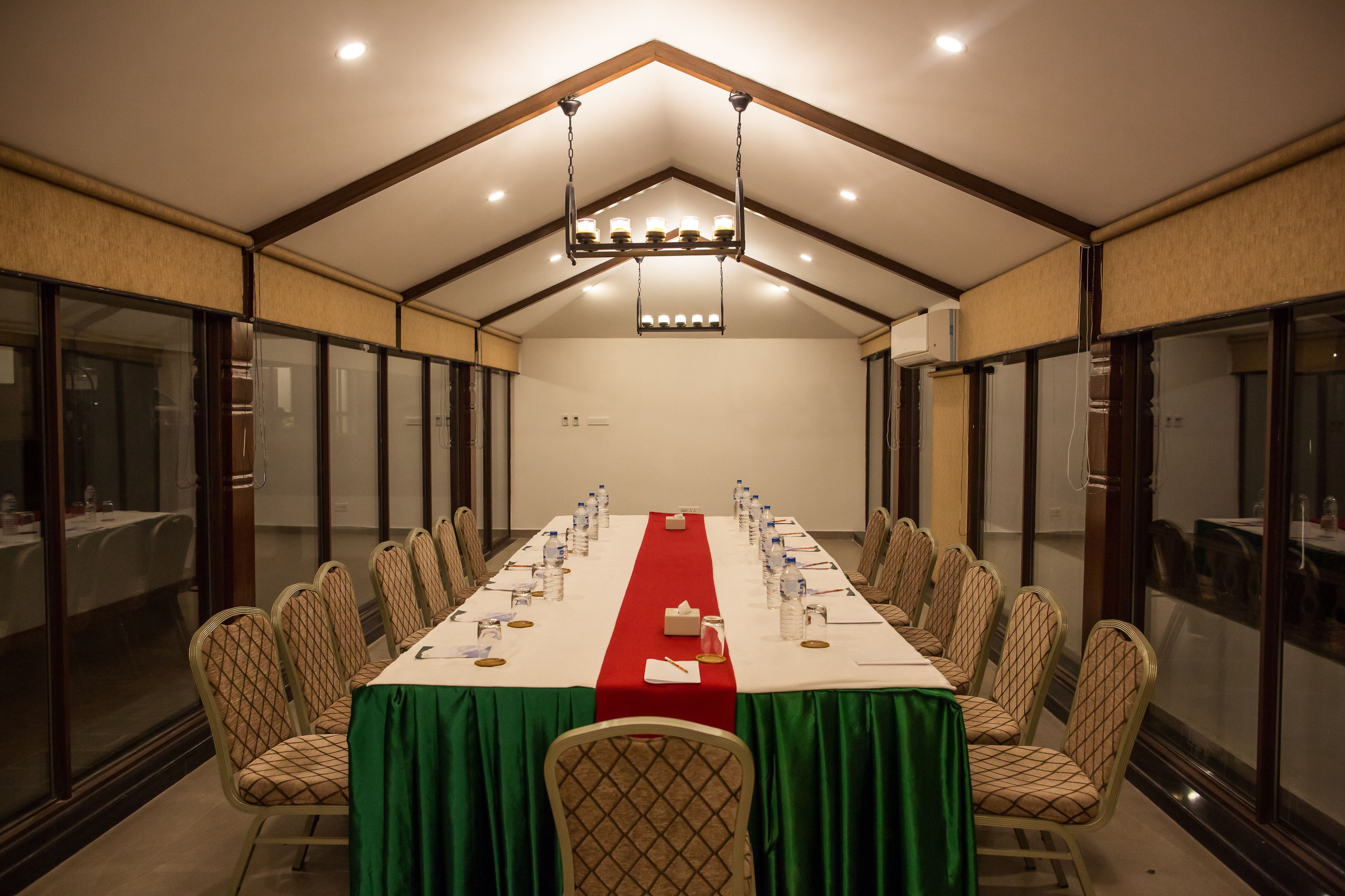 A conference room with a long table, chairs, and a chandelier.