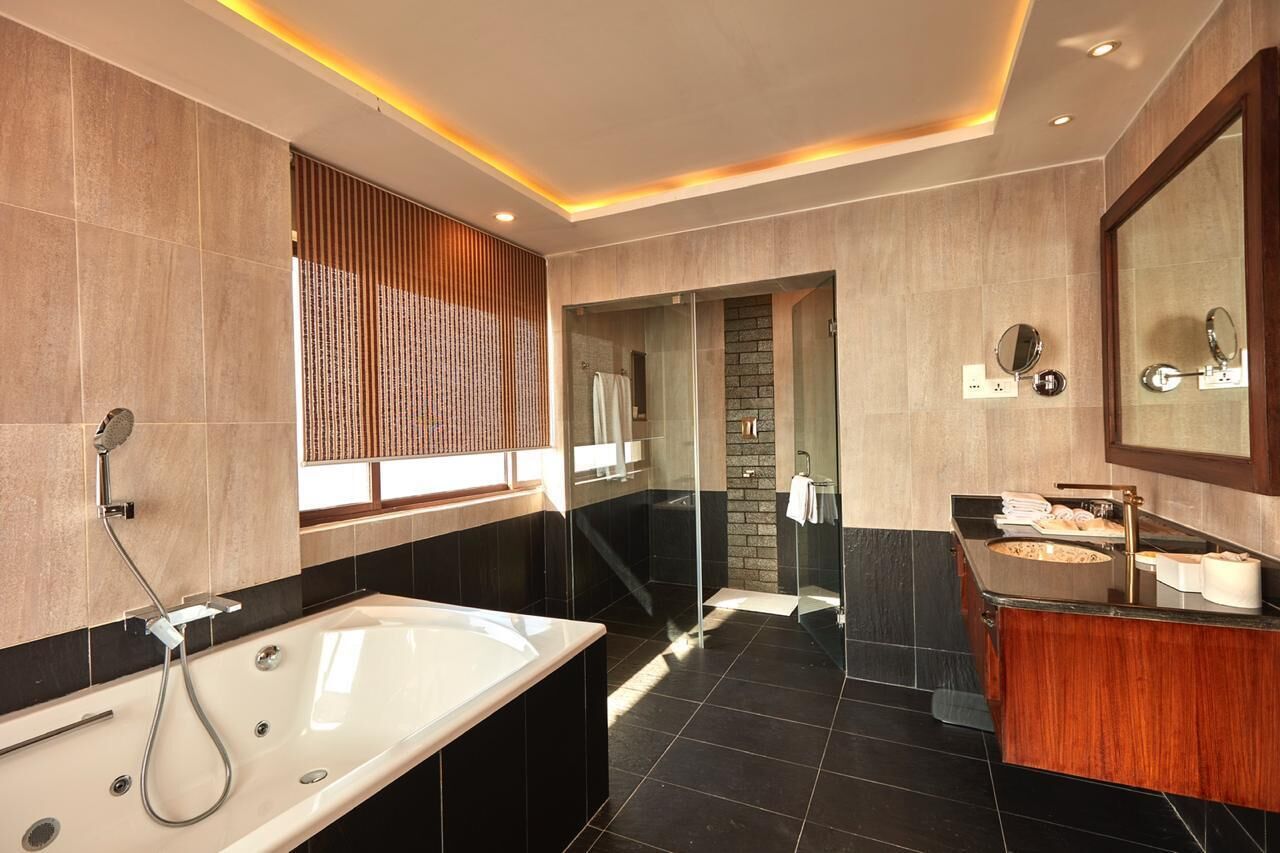 A modern bathroom with a large bathtub, a separate shower area, and a vanity with a sink and mirror.