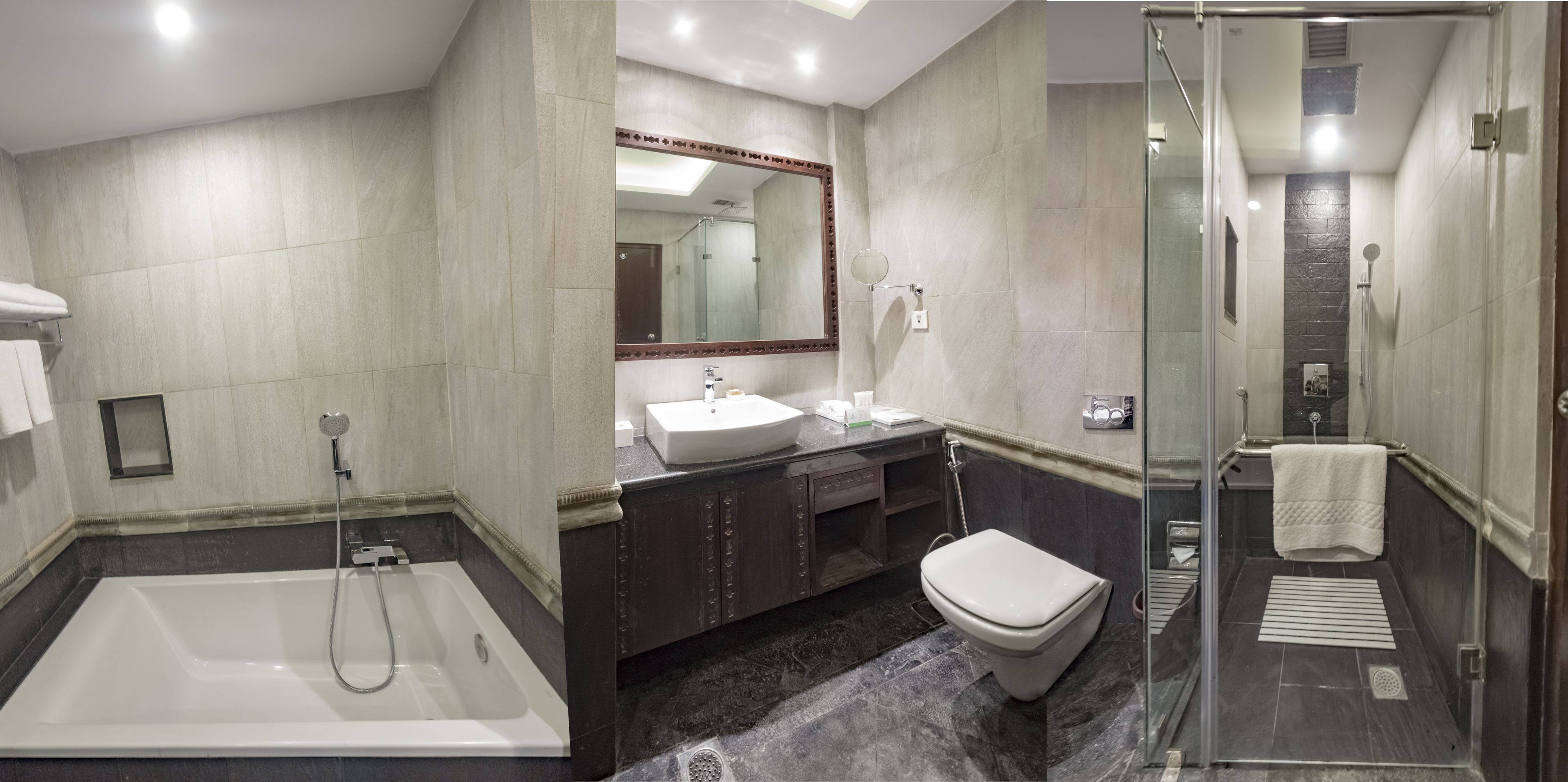 A modern bathroom with a bathtub, a sink, a toilet, and a glass-enclosed shower area.