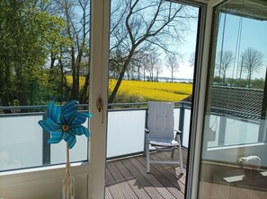 A balcony with a chair and a decorative flower.