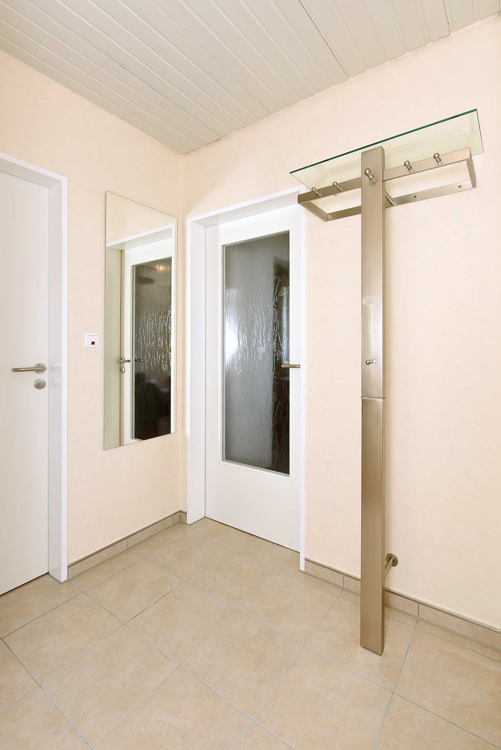 A room with two doors, one with a glass panel and a handle, and another with a frosted glass panel and a handle.