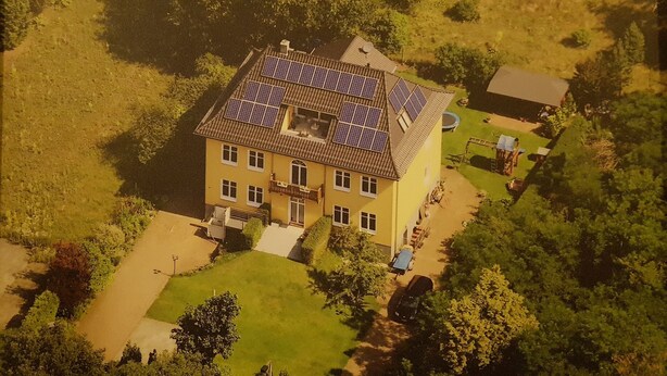 A two-story house with a sloped roof, solar panels, and a well-maintained lawn. - Apartment in Fürstenwalde (Fürstenwalde/Spree)