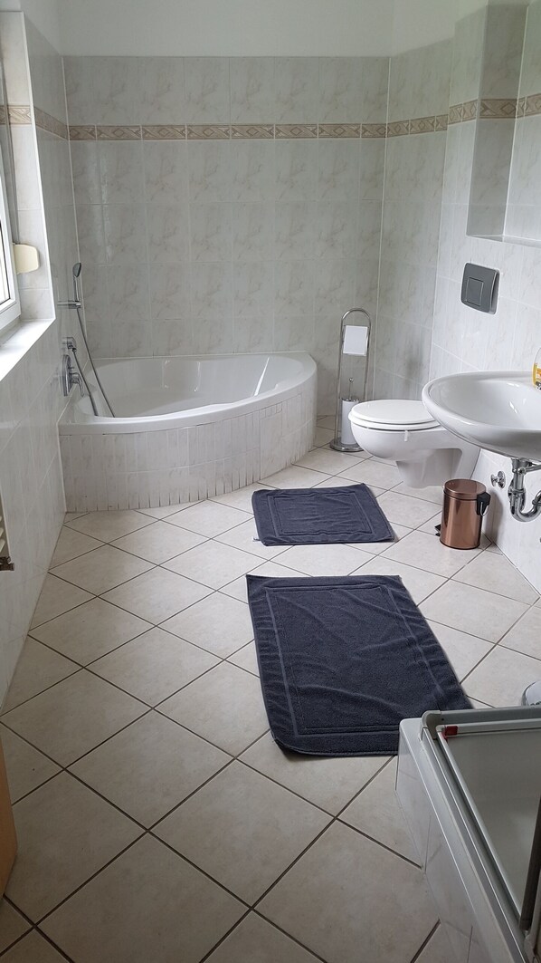 A bathroom with a bathtub, toilet, and sink.