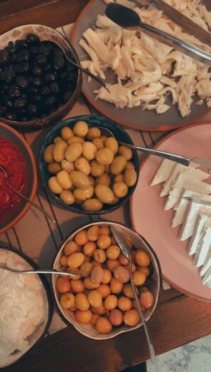 A table with various food items including olives, cheese, and other snacks. - Eagle Cave Inn (Ürgüp)