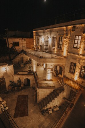 A multi-level courtyard with stone walls, a staircase, and outdoor seating areas. - Eagle Cave Inn (Ürgüp)