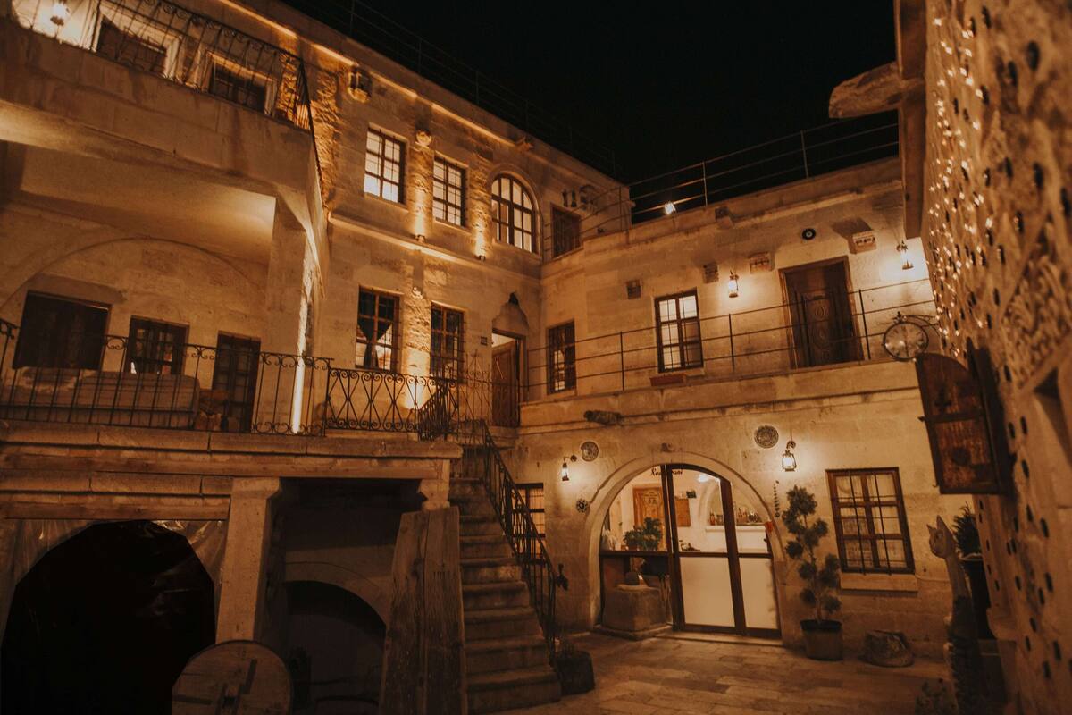 A historic building with multiple balconies, a central courtyard, and a staircase leading to an upper level.