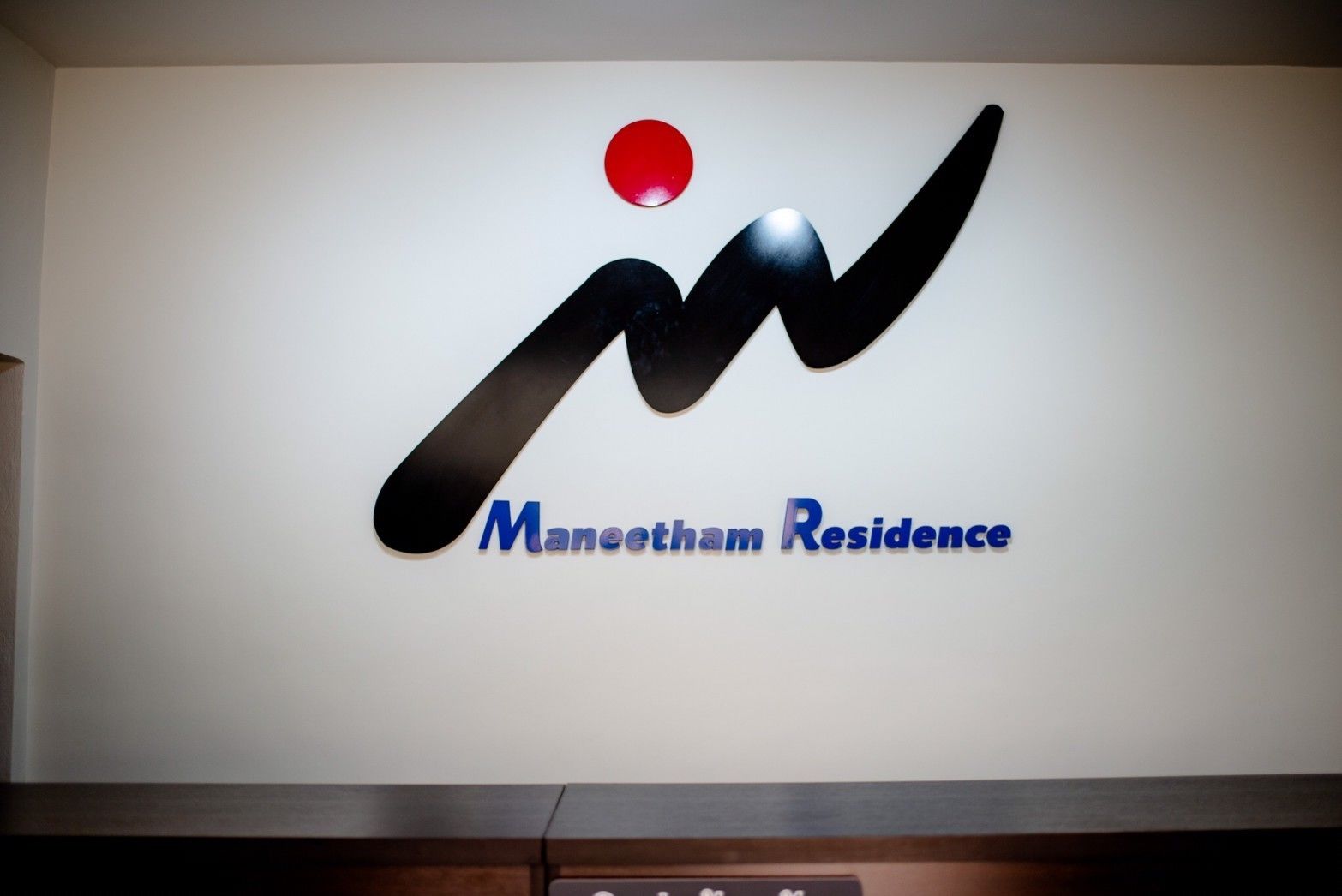 Un logotipo con una 'M' estilizada y el texto 'Maneetham Residence'.