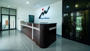 Una recepción con un logotipo, un televisor y una puerta de vidrio.