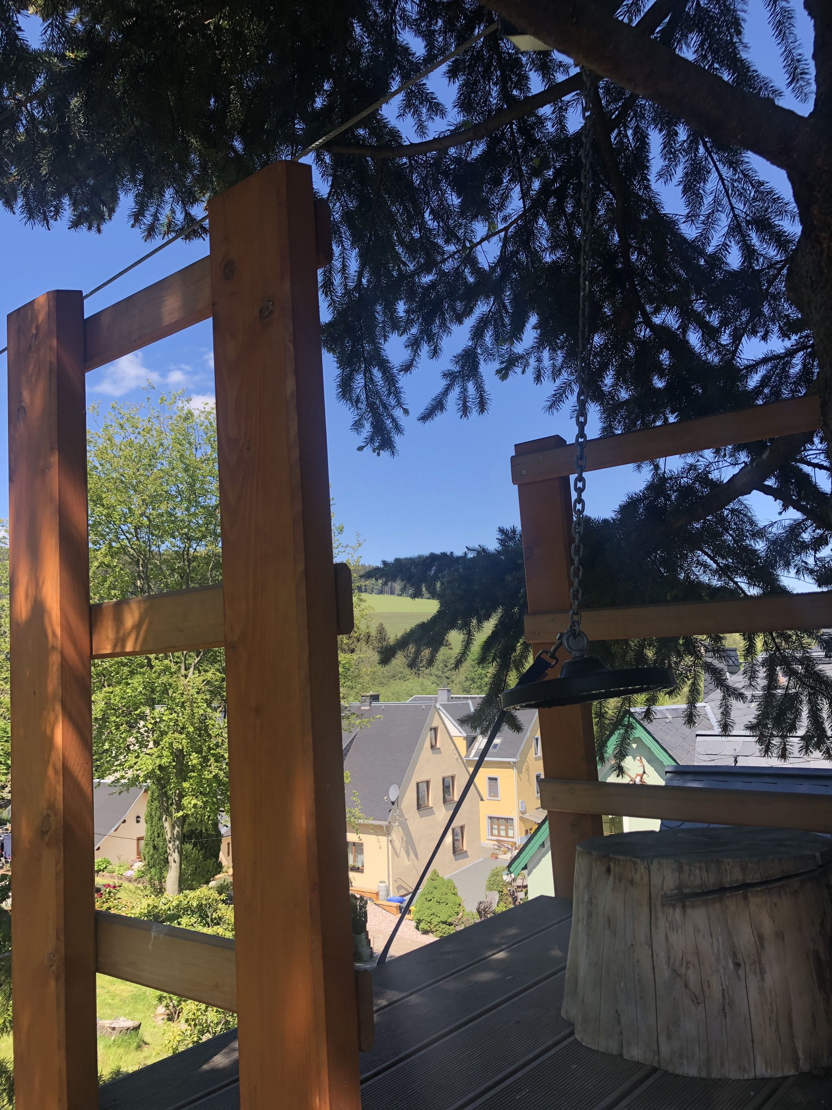 A wooden structure with a view of houses and trees.