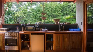 Cucina con piano cottura a gas, tostapane e cesti pensili.