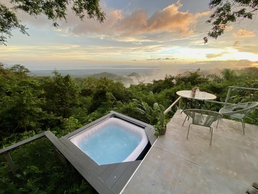 Un jacuzzi en una terraza con vistas a un paisaje montañoso.