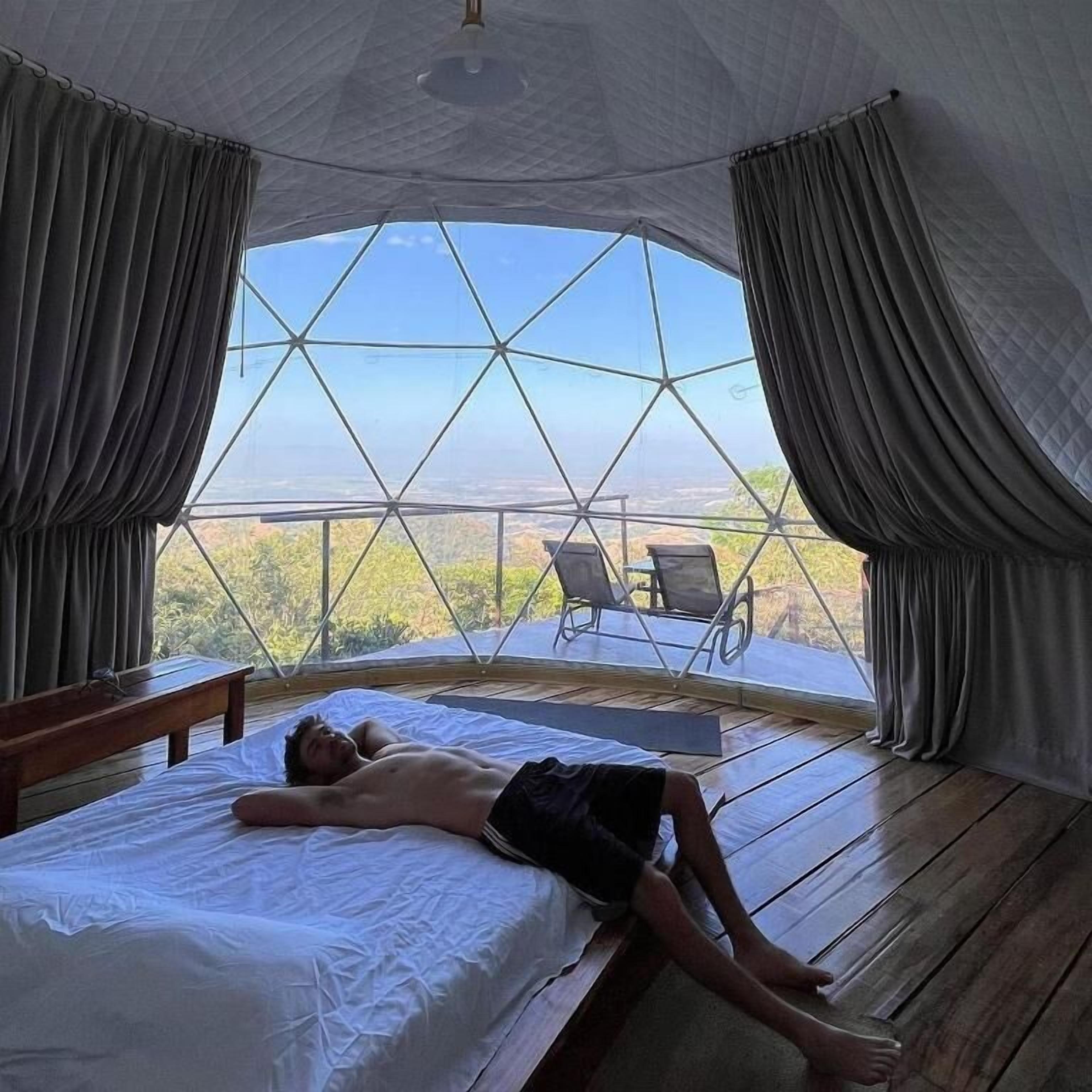 Una habitación con un ventanal grande, una cama y vistas al exterior.