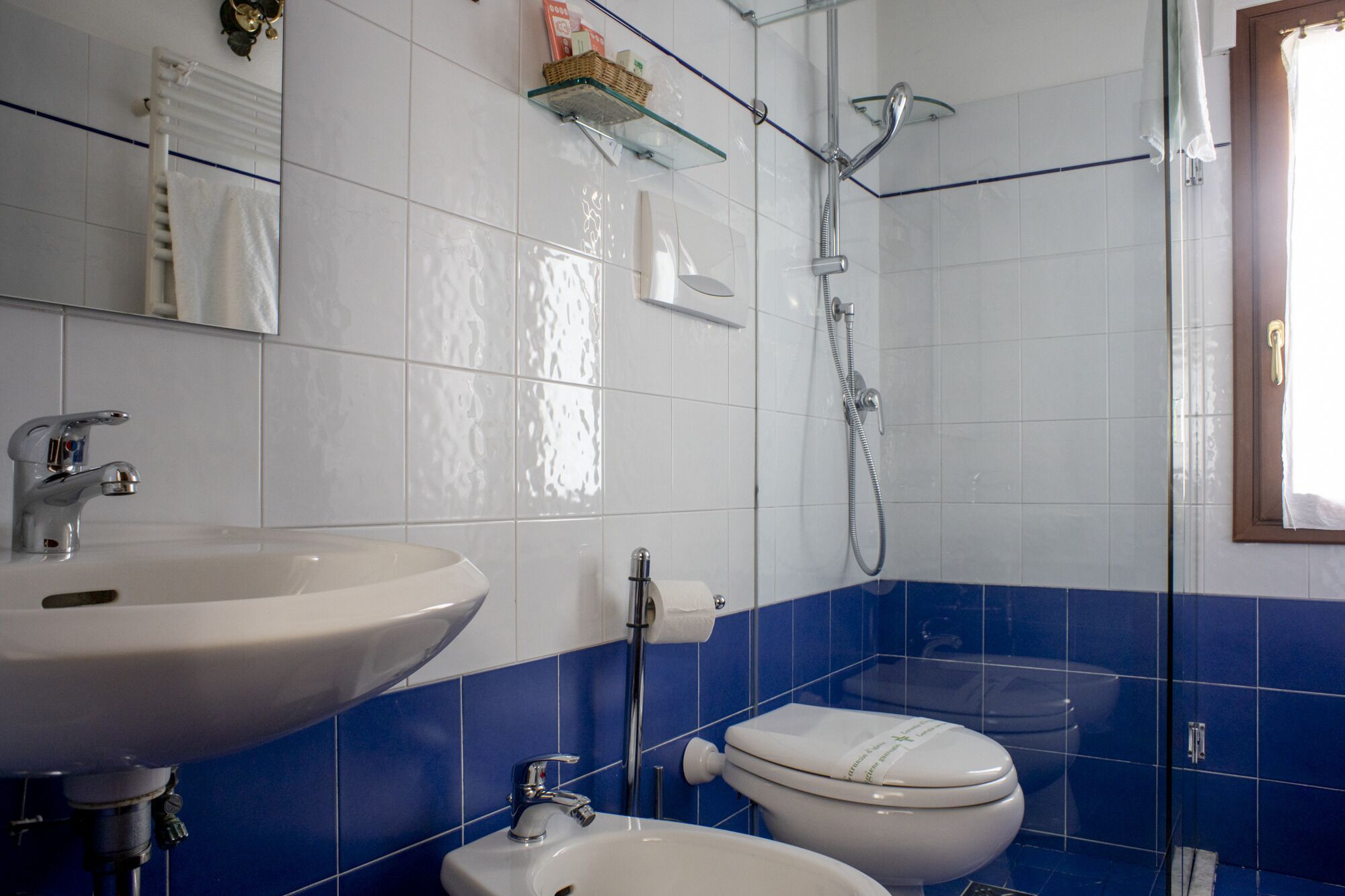 Un baño con lavamanos blanco, inodoro y ducha.